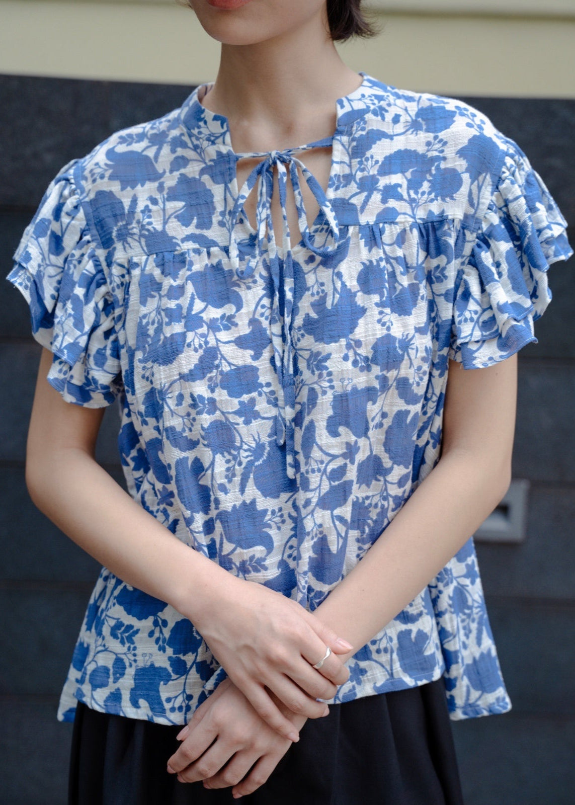 Woman wearing a blue floral blouse with a blurred background