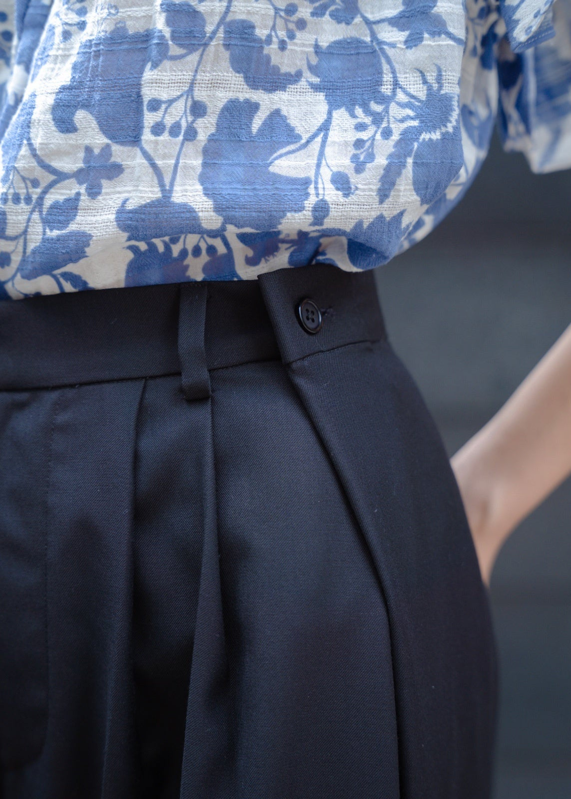 Navy pants with a floral-patterned shirt in the background