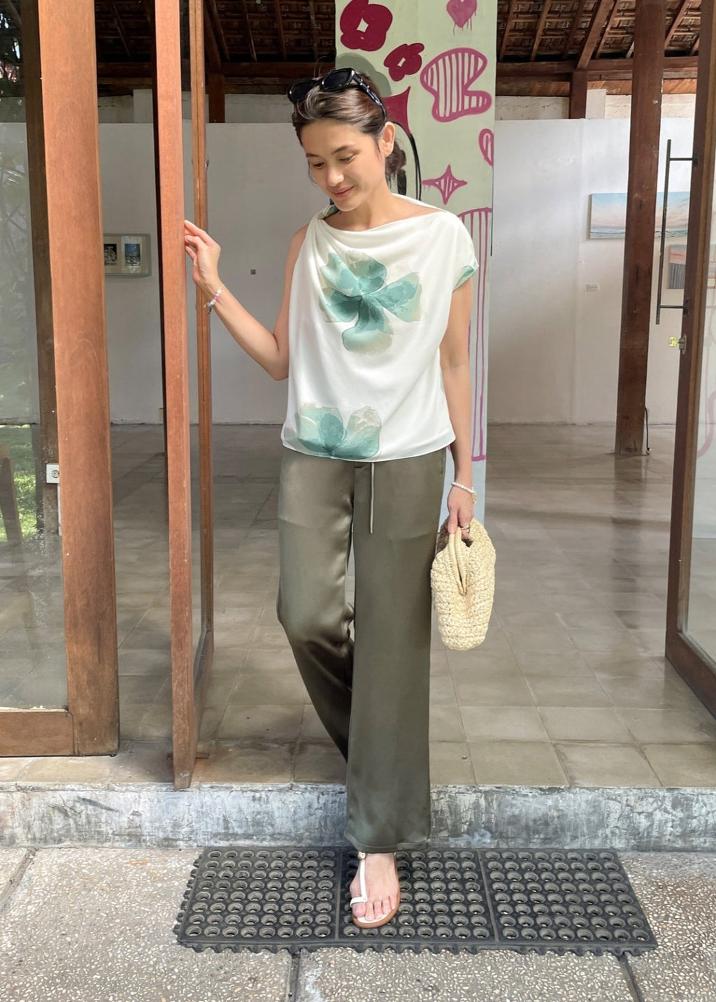 Woman standing in front of a glass door with a decorative background