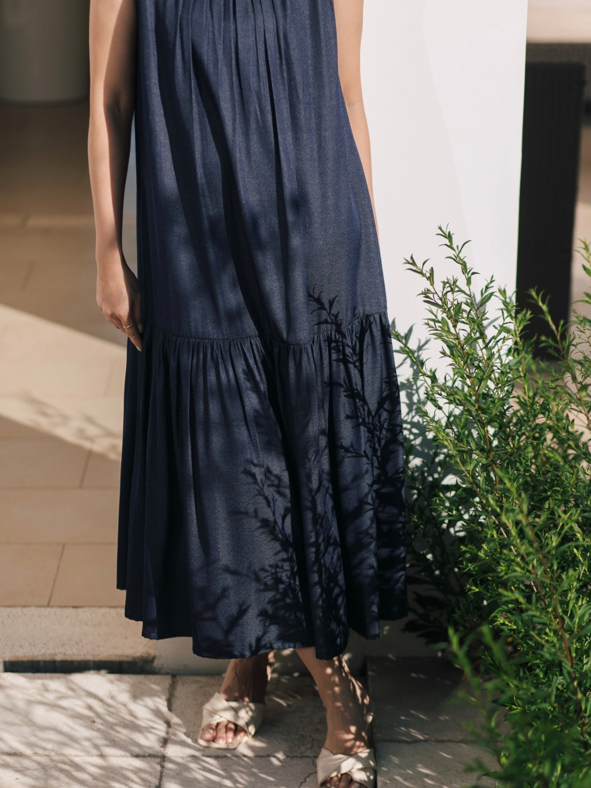 Person wearing a dark blue dress with floral patterns outdoors.